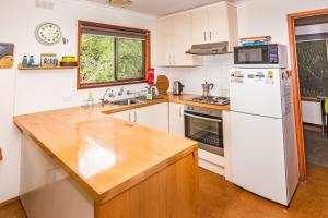 Sandy Pointにある18 Harbour View Sandy Pointの白い冷蔵庫とシンクのあるキッチン