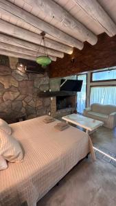 卢汉德库约Posada Via Vento - Chacras de Coria的一间带大床和石墙的卧室