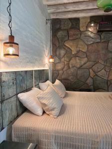 卢汉德库约Posada Via Vento - Chacras de Coria的一间卧室，配有一张床，墙是石的