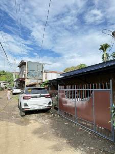 a car parked next to a fence next to a building at Davao City Cozy Home in Davao City