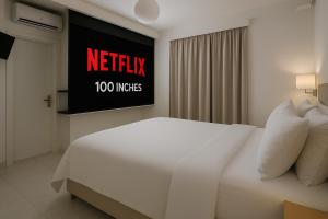 un letto bianco in una stanza d'albergo con un cartello di Alpha Studios Naxos - Adults Only a Naxos Chora