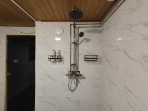 a bathroom with a shower with a white marble wall at Arctic Aurora Villa with a Lappish Grill Hut - Northern Lights and Private Sledding Hill in the Backyard, in the Hometown of Santa Claus, Rovaniemi in Rovaniemi +41 photos