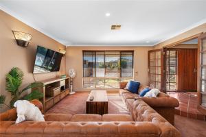 a large living room with couches and a tv at 5BR Beachside Home with Pool, Park Access in Perth