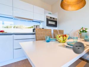 宾茨Ostsee-Traumferienwohnungen Bel Vital mit Meerblick, Balkon und Sauna的厨房配有白色橱柜和白色桌子