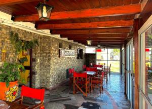 un ristorante con sedie rosse e un muro di mattoni di Hotel Pilar a Pilar