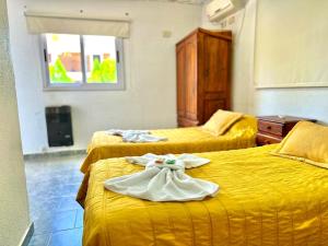 una camera d'albergo con due letti con asciugamani sopra di Hotel Pilar a Pilar