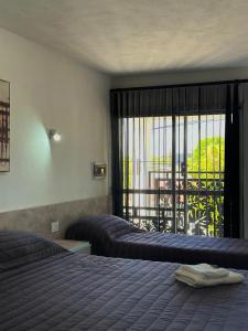una camera d'albergo con due letti e un balcone di Hotel Pilar a Pilar