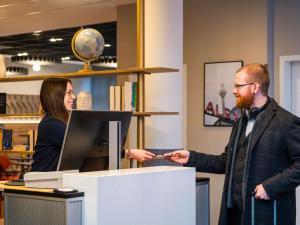 a man and a woman standing at a counter in a store at ibis Berlin Mitte in Berlin