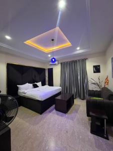 Un dormitorio con una cama grande y un sofá. en LEON'S HOTELS and SUITES OWERRI, en Owerri