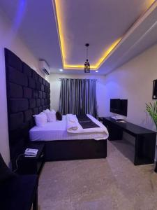 Un dormitorio con cama, escritorio y televisión. en LEON'S HOTELS and SUITES OWERRI, en Owerri
