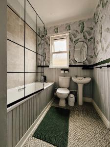 ein Badezimmer mit Toilette, Badewanne und Waschbecken in der Unterkunft Rock Ferry home in Birkenhead