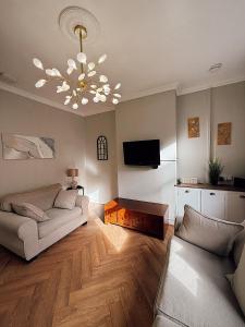 ein Wohnzimmer mit einer Couch und einem Kronleuchter in der Unterkunft Rock Ferry home in Birkenhead + 17 Fotos