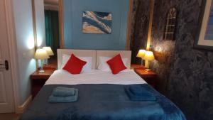 a bedroom with a bed with red and blue pillows at Rock Ferry home in Birkenhead