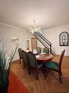 ein Esszimmer mit einem Holztisch und grünen Stühlen in der Unterkunft Rock Ferry home in Birkenhead