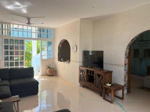 ein Wohnzimmer mit Sofa und Fernseher in der Unterkunft El Oasis in Chelem