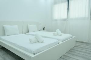 PrainhaEdifício Yes, Luxury 2 Bed Apartments, Praia, Cape Verde with Balcony and AC的配有2张床的客房,拥有白色的墙壁和地板