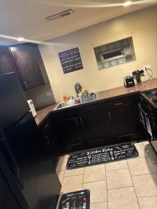 a kitchen with a black refrigerator and a sink at 420 Friendly 12 PM Check Out 1 Bedroom Basement in Chicago +4 photos