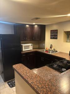 a kitchen with a black refrigerator and a microwave at 420 Friendly 12 PM Check Out 1 Bedroom Basement in Chicago