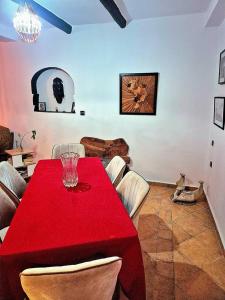 阿加迪尔Riad'Na的客厅里有一张红色桌子和几把椅子。