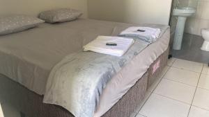 two towels are stacked on a bed in a bedroom at Aquarius Hoteis Ltda in Canarana