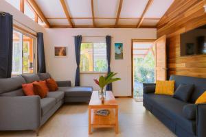 蓬塔乌巴Casa Amarilla in Playa Chiquita - with shared swimming pool -的有两张沙发和一张桌子的客厅