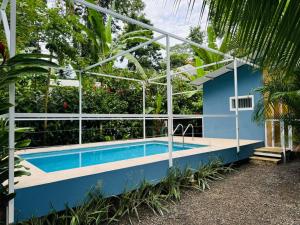 Casita Azul Studio with shared swimming pool في بونتا أوفا: بيت أزرق مع حوض سباحة في الحديقة