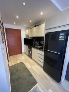 Una cocina con un frigorífico negro y un lavavajillas. en Alhambra Avenue, en Hurghada