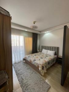 Un dormitorio con una cama y una ventana grande. en Alhambra Avenue, en Hurghada