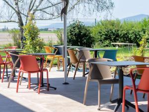 a group of tables and chairs sitting on a patio at Ibis Styles Colmar Nord in Colmar