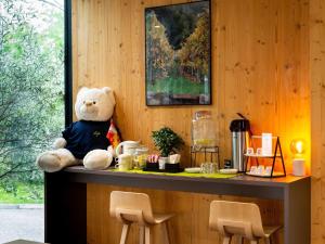 a stuffed teddy bear sitting on top of a counter at Ibis Styles Colmar Nord in Colmar