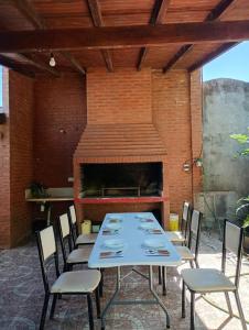 een terras met een tafel, stoelen en een open haard bij Quinta La Nubia in Paso de la Patria