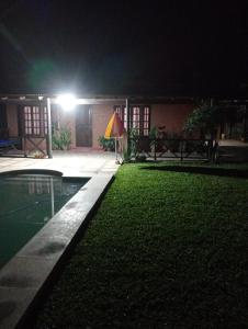een huis 's nachts met een zwembad ervoor bij Quinta La Nubia in Paso de la Patria