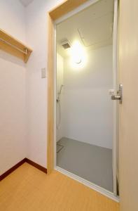 uma cabina de duche ao nível do chão num quarto com uma porta de vidro em ZEN Hostel em Yamanouchi