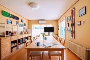 a dining room with a table and chairs at Yellow House Niseko in Kutchan