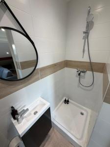łazienka z wanną, umywalką i lustrem w obiekcie T2 Neptune x4 people NEW Gare parilly w mieście Vénissieux