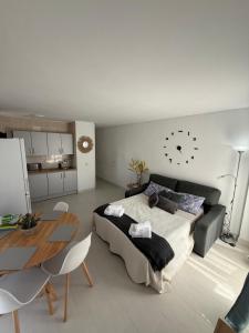 una camera da letto con un letto e un tavolo e un orologio a muro di Minerva 518- Garden View a Benalmádena