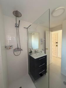 un bagno con lavandino e doccia in vetro di Minerva 518- Garden View a Benalmádena