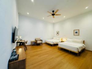 Un dormitorio con dos camas y un ventilador de techo. en 1917 By MUO, en Muar