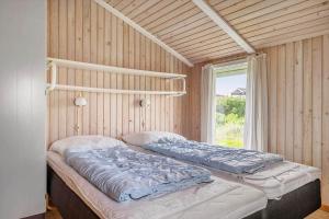 two beds sitting in a room with a window at 641-Hvide-Sande-Julianevej-13 in Bjerregård