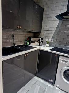 una cocina con fregadero y estufa en Cambridge suites, en Cleethorpes