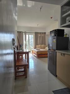 Una cocina y una sala de estar con un sofá. en Studio Unit near Mines View Park, Baguio City, en Baguio