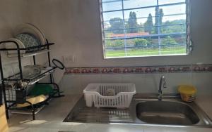 a kitchen sink with a drying rack next to a window at Mi pueblo Hostal Nahuizalco in Nahuizalco +32 photos