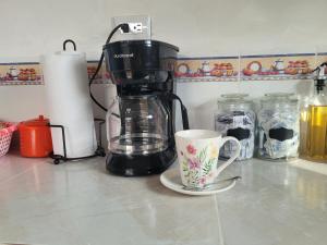 a coffee maker and a coffee cup on a counter at Mi pueblo Hostal Nahuizalco in Nahuizalco