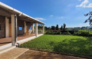 a porch of a house with a green lawn at Mi pueblo Hostal Nahuizalco in Nahuizalco