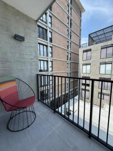 グアダラハラにあるFurnished loft in Ciudad Granja with balconyのバルコニー(赤い椅子付)