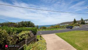 a road with a car parked on the side of the road at Beachview Unit2 ,33 Scenic Drive, Bermagui in Bermagui