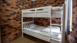 two bunk beds in a room with a brick wall at Beachview Unit2 ,33 Scenic Drive, Bermagui in Bermagui