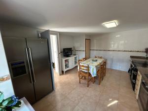 una cucina con tavolo e frigorifero di Casa Carmen e do Hilario a Ponte Do Porto