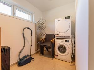 a laundry room with a washing machine and a chair at Grebenzen Lodge 51 in Sankt Lambrecht