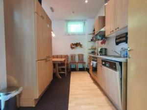 Una cocina con gabinetes de madera y una mesa en ella. en one bedroom apartment, en Farnau